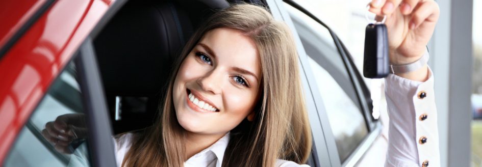 Smiling woman dangling keys through driver side window